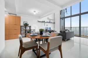 a dining room and living room with a table and chairs at Sovrae by Kozystay - Grogol in Jakarta