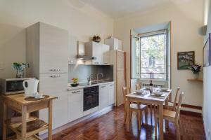 eine Küche mit einem Tisch und eine Küche mit weißen Schränken in der Unterkunft At Rome St. Peter's in Rom
