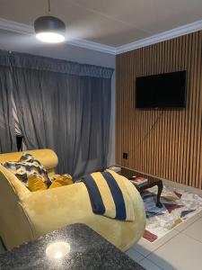 a living room with a couch and a flat screen tv at Black Olive Haven in Fourways