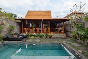 a villa with a swimming pool and a house at Ithaca Ubud Villa in Ubud