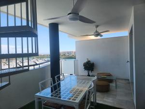 a dining room with a table and a ceiling fan at Ático Lagomar in Almería