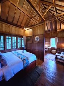 sypialnia z dużym łóżkiem w pokoju z drewnianymi ścianami w obiekcie Manigelang Villa w mieście Singaraja