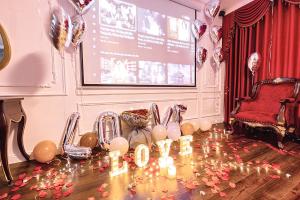 a projection screen with candles and balloons on a table at Hoang Gia Hotel Ha Noi Capital in Hanoi
