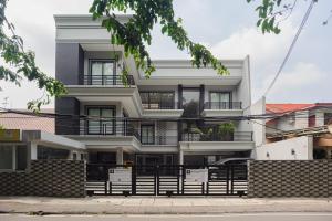 - un bâtiment blanc avec balcon dans une rue dans l'établissement RedDoorz near Jakarta International Velodrome, à Jakarta