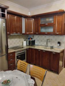 a kitchen with wooden cabinets and a table with a bowl of food at Linda's apartment in Agia Triada