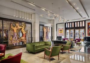 a lobby with a green couch and chairs at The Joule in Dallas