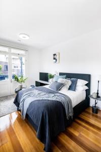 una camera da letto con un grande letto con cuscini blu di Not your usual studio apartment a Sydney