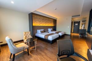 um quarto de hotel com duas camas e uma mesa e cadeiras em MetroCentre Hotel em Tagbilaran