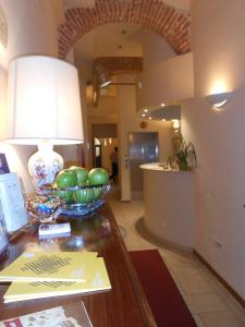 a room with a table with a lamp and green bowls on it at Hotel Atlantic in Bologna