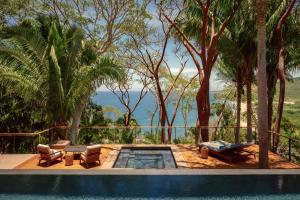 ロ・デ・マルコスにあるOne&Only Mandarinaの海の景色を望むリゾートプール(椅子付)