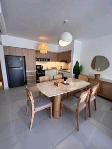 Una cocina y un comedor con mesa y sillas. en Marassi North Coast, en El Alamein