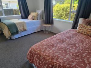 1 dormitorio con 1 cama y ventana con asiento junto a la ventana en Casa Blue, en Whitianga