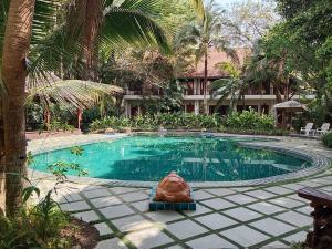 a swimming pool in a resort with a statue in front of it at Rachawadee Khonkaen Airport Hotel in Khon Kaen
