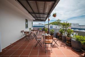 a patio with chairs and tables on a balcony at Alba Sand Hotel & Spa Phú Quốc in Phu Quoc