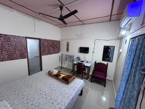 a bedroom with a bed and a table with a chair at Orchid Park Homestay in Sibsāgar