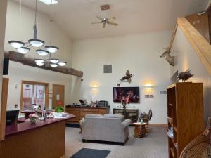 Una sala de estar con un sofá y un televisor. en Ausable Valley Inn, en Mio 5 fotos más