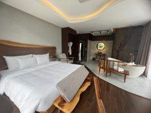 a bedroom with a large bed and a bathroom at Minawa Kenhga Resort & Spa Ninh Binh in Ninh Binh
