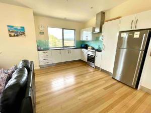 a kitchen with a stainless steel refrigerator and wooden floors at Dune Escape - beach tranquility in Emu Bay