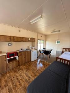 eine Küche mit einem Bett und einem Tisch in einem Zimmer in der Unterkunft Stawell Grampians Gate C & C Park in Stawell