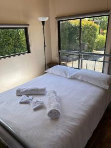białe łóżko z ręcznikami i oknem w obiekcie Stawell Grampians Gate C & C Park w mieście Stawell