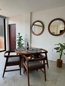 ein Esszimmer mit einem Tisch und 2 Spiegeln in der Unterkunft Nabani Condominios T1 in Santa Cruz Huatulco + 27 Fotos