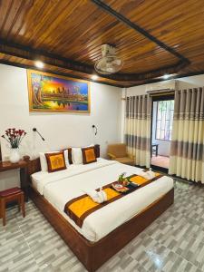 ein Schlafzimmer mit einem großen Bett in einem Zimmer in der Unterkunft Luang Prabang Oudomlith Villa & Travel in Luang Prabang