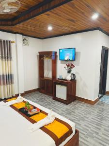 a room with two beds and a flat screen tv at Luang Prabang Oudomlith Villa & Travel in Luang Prabang