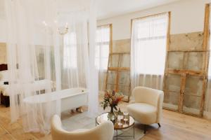 a bathroom with a tub and a chair and a table at Artisan in Kuldīga