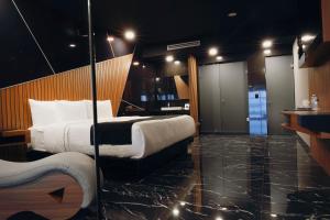 a hotel room with a large bed and a bathroom at Hotel Yoru in Querétaro