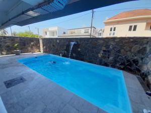 a swimming pool in the backyard of a house at Seaside Escape Apartment in Flic-en-Flac