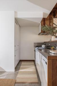 a kitchen with white cabinets and a kitchen rug at The Seaport Burleigh in Gold Coast