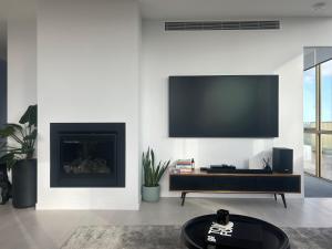 a living room with a flat screen tv on a wall at Soho Penthouse - Luxury lifestyle property in Prahran in Melbourne