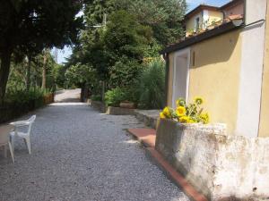 a street with a building and a bench and flowers at Residence La Casina in Castagneto Carducci