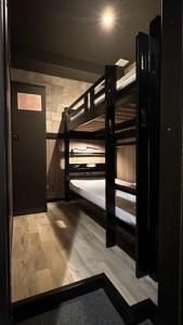 Cette chambre comprend 2 lits superposés et une porte. dans l'établissement Hotel Capsule Inn Shizuoka, à Shizuoka