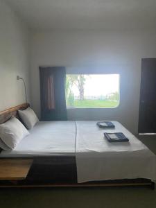 um quarto com uma cama grande e uma janela em East Lombok Dive Hotel - 3 private rooms on the beach with seaview & scuba diving center em Labuhan Pandan