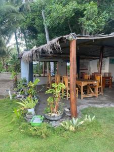 um restaurante com mesa, cadeiras e plantas em East Lombok Dive Hotel - 3 private rooms on the beach with seaview & scuba diving center em Labuhan Pandan