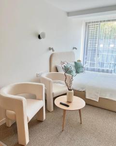 a bedroom with two chairs and a bed and a table at Apartamentai-studija Palangos kopos in Palanga