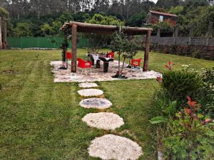 a garden with a table and chairs in a yard at Casa da Loura - Costa da Morte in Dumbría