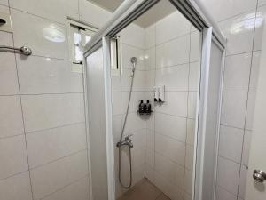 a shower with a glass door in a bathroom at 八八古藝悅禾民宿 in Jinning