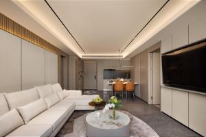 un soggiorno con un divano bianco e una TV di Wilmton Art Hotel Guangzhou Nansha UNI MALL a Canton