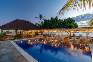 a resort swimming pool with chairs and a table at Nusa Indah Bungalow in Nusa Lembongan