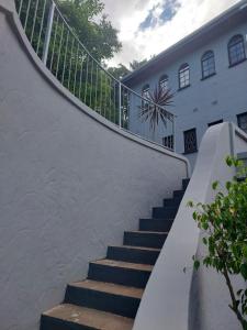 una escalera que conduce a un edificio blanco en Fairway Guest Lodge, en Margate