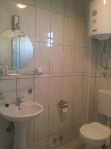 W łazience znajduje się umywalka, toaleta i lustro. w obiekcie Luce di Sole Apartment w Ulcinju