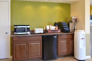 a kitchen with a counter with a microwave and a refrigerator at Budget Inn Expressway Hub in Rohnert Park