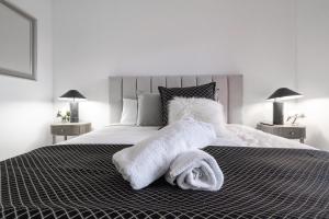 a bedroom with a bed with towels on it at CBD Apartments by the International in Wagga Wagga +18 photos