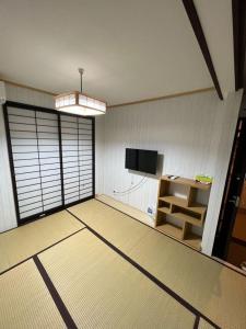 an empty room with a tv and a desk in it at 明和荘Mei Wa Inn in Kyoto