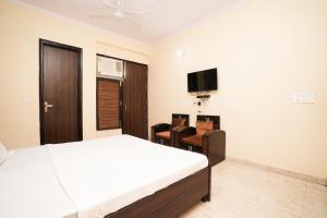 a bedroom with a bed and a tv on the wall at Prince Villa in Gurgaon