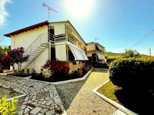 a white building with a staircase in front of it at 4 Seasons apartments in Himare