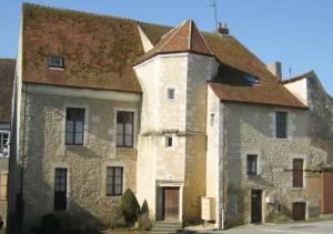 an old stone building with a brown roof at Charmant duplex au calme "La Tourelle" avec wifi in Rémalard en Perche