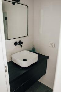 une salle de bain avec un lavabo et un miroir dans l'établissement New Duplex - Next mamila, à Jérusalem